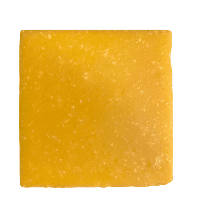 Square piece of yellow cheese on white.